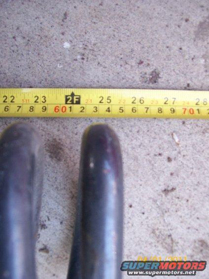 Two dark metal pipes, one mostly visible, with a yellow measuring tape in the background