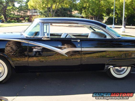 Side view of a black 1956 Ford Victoria with chrome trim and whitewall tires