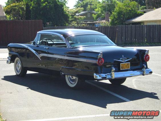Dark blue 1956 Ford Fairlane rear 3/4 view with chrome accents and whitewall tires