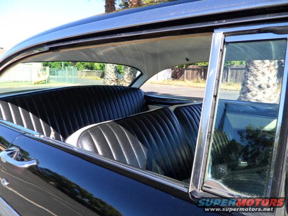 Black vinyl pleated seats and chrome trim inside a 1956 Ford Fairlane