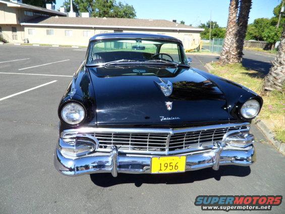 Black 1956 Ford Fairlane front view with chrome grille and yellow license plate