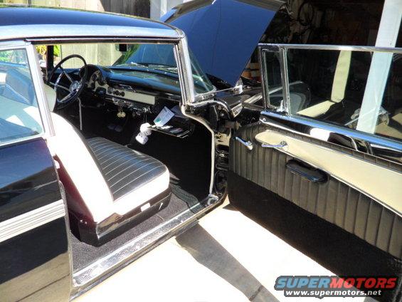1956 Ford Fairlane interior showing front seats, dashboard, and door panel
