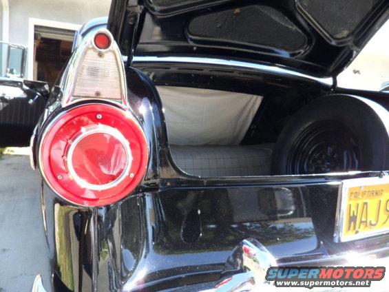 Black 1956 Ford Fairlane trunk open, showing spare tire and interior. California license plate WAJ9