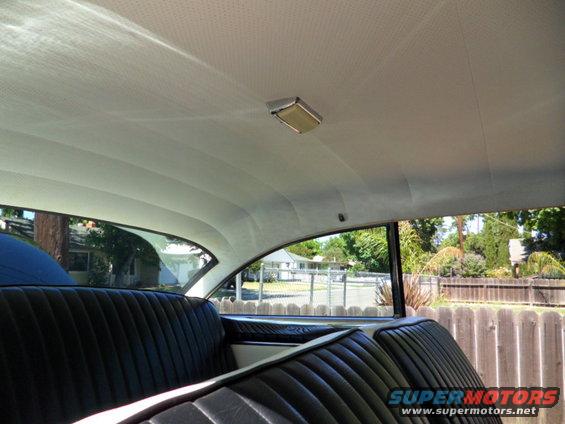 Interior view of a 1956 Ford Fairlane showing the headliner, dome light, and rear bench seat