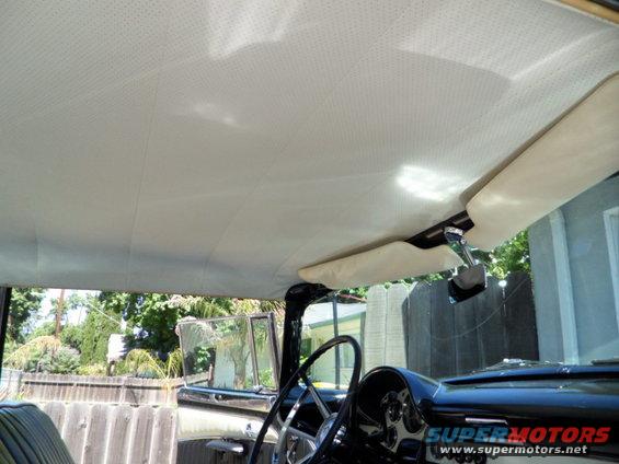 1956 Ford Fairlane interior showing beige headliner, sun visors, steering wheel, and dashboard