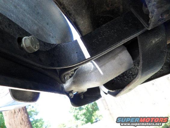 Underside view of vehicle suspension with exhaust pipe visible