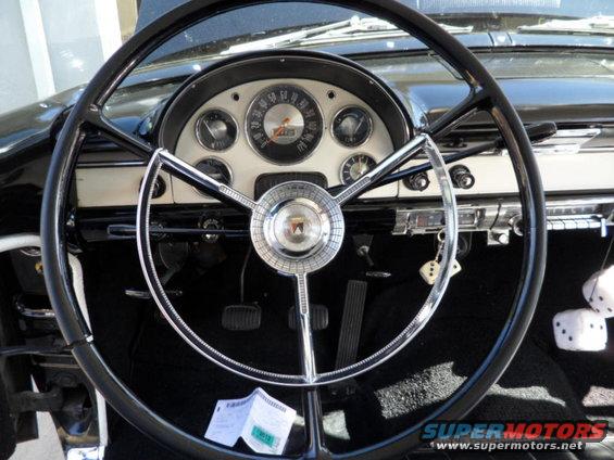 1956 Ford Fairlane interior dashboard with a large steering wheel, chrome accents, and gauges