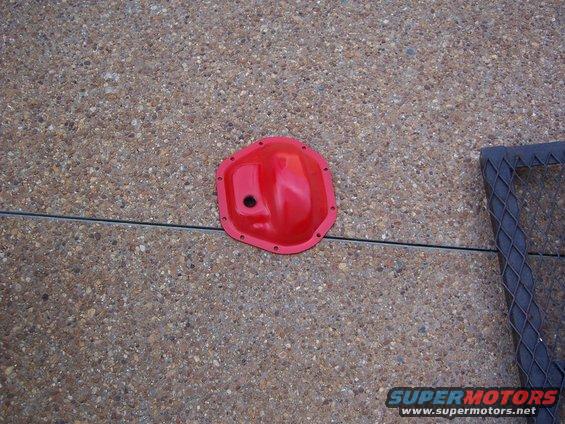 Red aftermarket differential cover on concrete