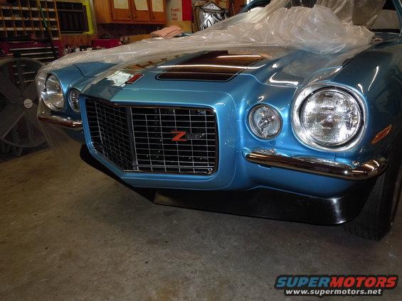 Blue Chevrolet Camaro Z28 front grille with black stripes on hood, covered partially with plastic