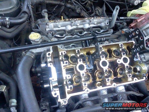 Engine internals with valve cover removed, showing camshafts and valves