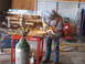 1994 Ford Bronco - A person is using an angle grinder to cut metal, creating a shower of sparks in a workshop setting.