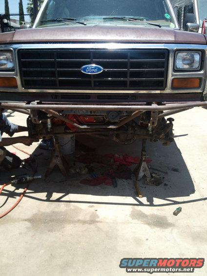 Brown Ford Bronco front end on jack stands, grille visible, front suspension removed