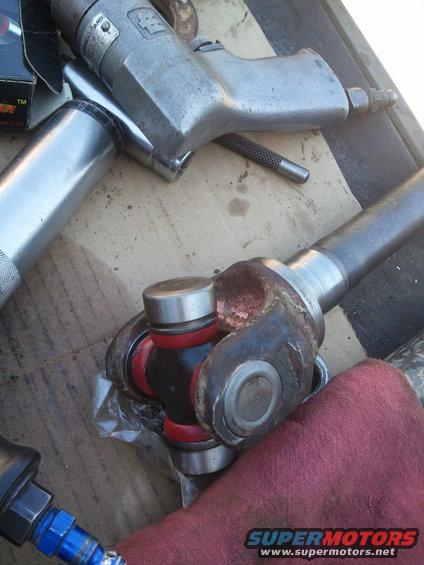 Universal joint with red and black components, alongside air tools and a red cloth