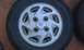 1991 Ford Festiva - A close-up view of a single silver alloy wheel with a visible Ford emblem.