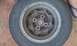 1991 Ford Festiva - A single wheel and tire assembly is shown, likely removed from a vehicle.