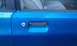 1991 Ford Festiva - Close-up of a blue car's exterior door handle and lock mechanism.