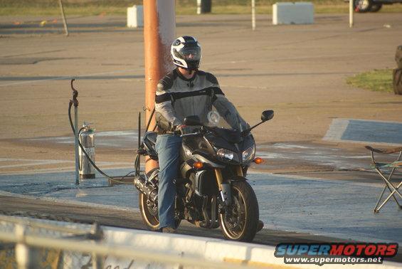 Black 2008 Yamaha FZR1000 motorcycle with a rider wearing a helmet and riding gear