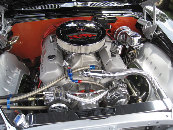 Engine bay with a polished V8 engine, chrome air cleaner with '427 Anniversary' text, and orange firewall