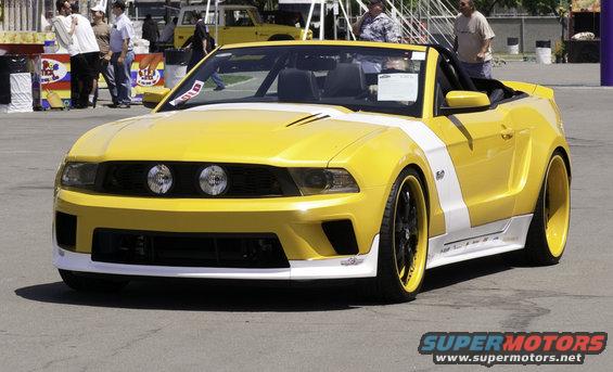 Yellow convertible Ford Mustang with white stripes and custom wheels, front 3/4 view