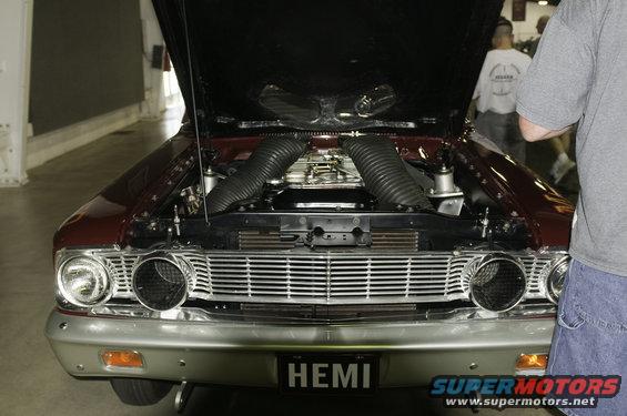 Front view of a classic car with hood open, showing dual air intakes and a HEMI license plate