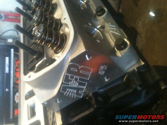 Engine cylinder head with H&R logo and 302 CC marking. Visible valve springs and bolts