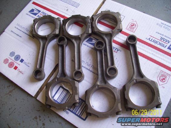 Set of five connecting rods on a cardboard box