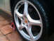 1999 Mercury Grand Marquis - A single wheel and tire assembly is shown, likely from a Porsche, with a red jack stand visible.