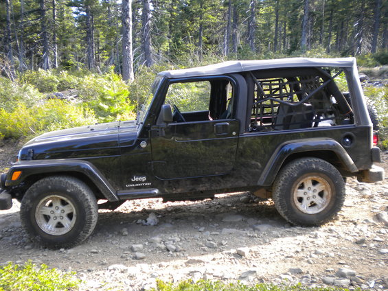 Black 2005 Jeep Wrangler Unlimited side view on a dirt road