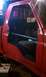 1994 Ford F-250 - Interior view of a red pickup truck with the driver's side door removed, revealing the seats and a roll bar.