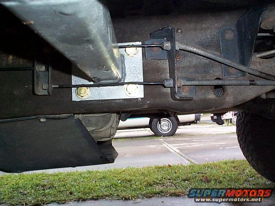 driversiderear.jpg Rear driver's side pad mounting, there is about a 1/4 inch clearance between the ebrake cable and the are. The holes drilled here, must be drilled very carefully, preferably with assistance by someone who can pull the fuel lines away from behind the rail.