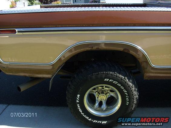 1979 Ford F-150 truck's rear wheel and fender, tan and brown paint, diamond plate trim