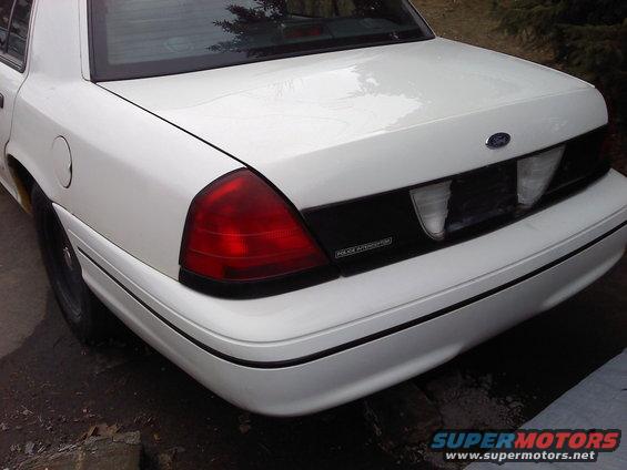 White Ford Crown Victoria rear, showing taillight, trunk, and "POLICE INTERCEPTOR" text