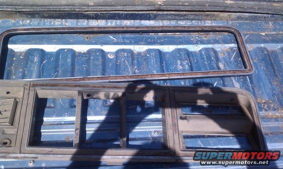 Grille trim and window trim pieces on a blue truck bed