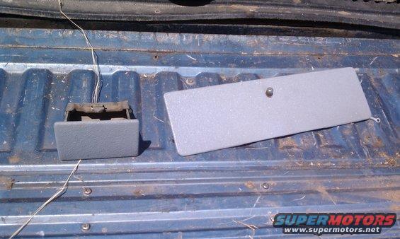 Gray ashtray and cover removed from a vehicle bed