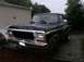 1978 Ford Bronco - A black 1978 Ford Bronco is parked in front of a building on a rainy day.