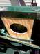 1978 Ford Bronco - A wooden enclosure with a large circular opening is mounted inside a vehicle's green interior, with wires visible.