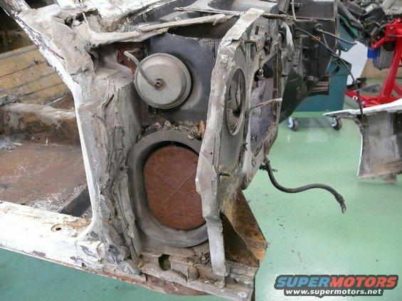 Corvette chassis part with rusted circular component and brake line