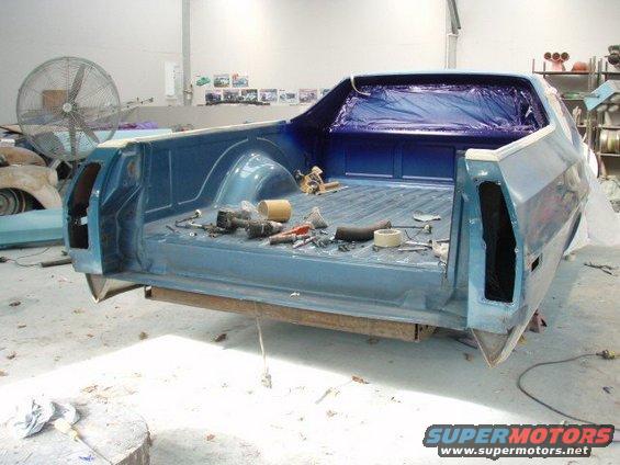 Rear view of a blue 1973 Ford Ranchero bed with tools and masking tape