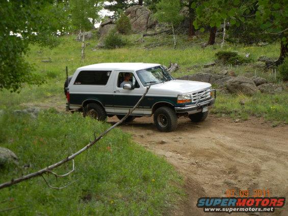 White and green 1996 Ford Bronco on a dirt road