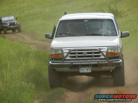 1996 Ford Bronco front view on dirt road, Jeep in background