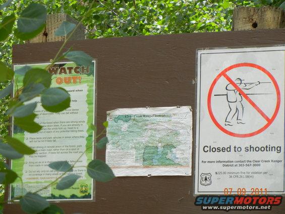 Bulletin board with 'Watch Out!' sign, map, and 'Closed to shooting' sign
