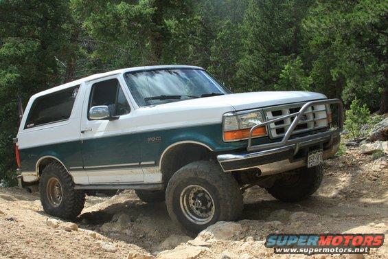 White and teal 1996 Ford Bronco on a rocky trail