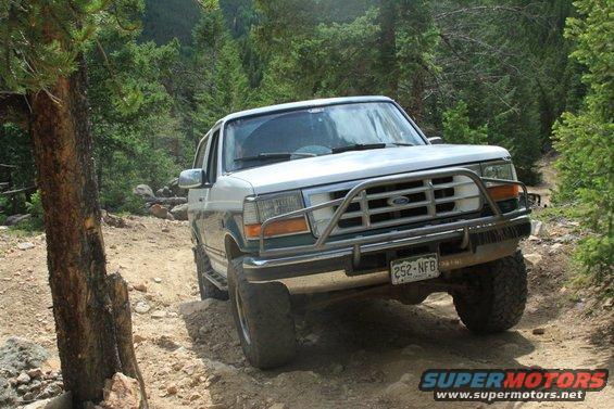 1996 Ford Bronco driving on a rocky, wooded trail. License plate 252-NFB