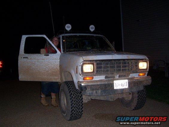 1988 Ford Bronco II, mud-splattered, driver's door open, person inside. License plate 1CV-4613