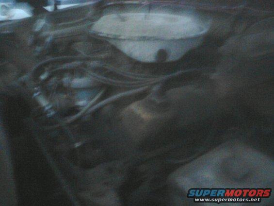 Engine bay with hoses and a white cap