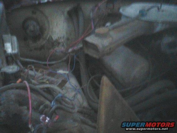 engine bay with lots of wires and some engine parts