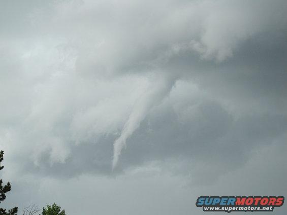 Tornado funnel cloud forming in stormy grey clouds