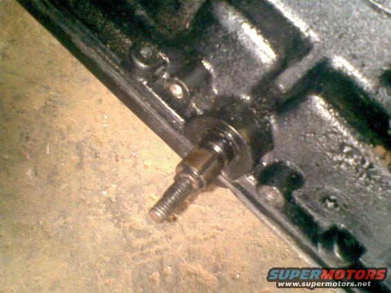 Close-up of a metal engine part with a threaded bolt sticking out