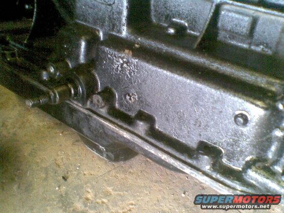 Close-up of a black metal mechanical part with bolts and levers visible