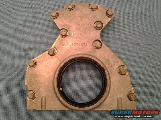 Metal engine part with a circular seal and bolt holes, marked 12572014 TP